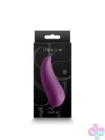Desire Kama rechargeable clitoral vibrator in beige and purple on a soft neutral background