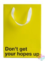 Yellow Kraft paper gift bag printed with Don't Get Your Hopes Up and white ribbon handle