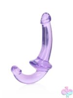 RealRock Crystal Clear Strapless Strap-On standing upright showing dual-ended design in four color options