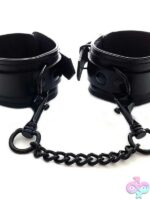 Black leather ankle cuffs with black metal hardware and detachable chain by Rouge Garments