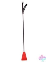 Rouge PVC riding crop in black and red on a dark surface showing wrist loop and flexible shaft